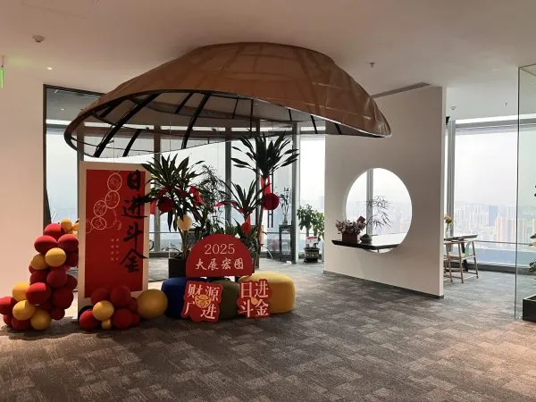Modern interior lounge area of Shoulder Tent's new headquarters, featuring a unique tent-style ceiling structure, panoramic city views, and festive decorations for 2025.