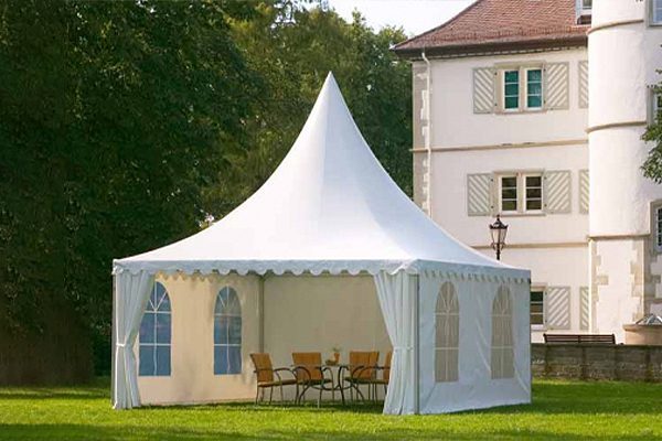 White high peak pagoda tent featuring PVC sidewalls with clear arched windows set up on a lawn.